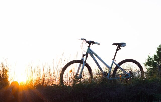 Vélo dans un champ avec coucher de soleil